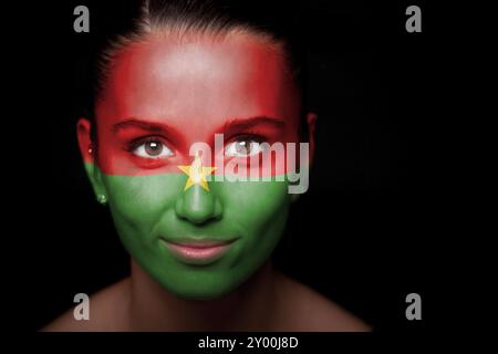 Porträt einer Frau mit der Flagge der Burkina faso im Gesicht Stockfoto