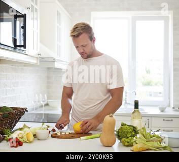 Hübscher junger Mann Kochen zu Hause vorbereiten Salat in Küche Stockfoto