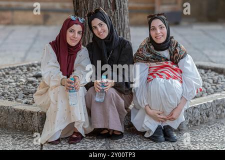 SARAJEVO, BOSNIEN UND HERZEGOWINA - 24. AUGUST 2024: Junge, schöne muslimische Mädchen, freundlich und lächelnd, im Innenhof des Gazi Husrev-Begov VAKU Stockfoto