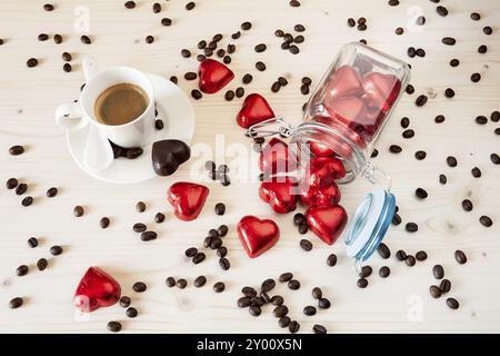 Rot Schokolade Herzen in einem Glas und einer Tasse Espresso Kaffee mit Kaffeebohnen auf eine Tabelle von oben gesehen Stockfoto