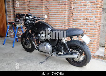 Ein klassisches Motorrad steht in einer Kreativwerkstatt. Motorrad im Vintage-Stil in einer Garage. Stockfoto