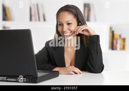 Corporate Frau im Gespräch über ihre Kopfhörer in einem Büro Stockfoto