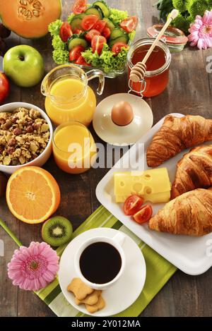 Das Frühstück, bestehend aus Obst, Orangensaft, Kaffee, Honig, Brot und Ei. Ausgewogene Ernährung Stockfoto