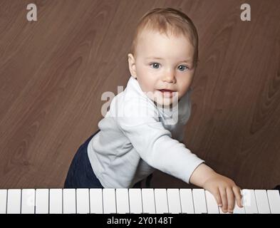 Porträt eines kleinen Kindes, das Musik auf schwarz-weißer Klaviertastatur spielt Stockfoto