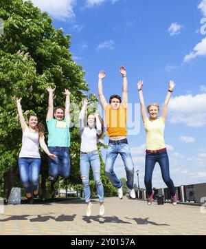 Gruppe von lächelnden Jugendlichen springen im Freien. Freundschaft-Konzept Stockfoto