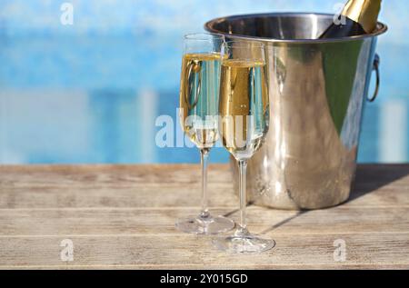 Champagner Gläser und Flaschen in den Eimer für das Eis in der Nähe von Schwimmbad. Ferienhäuser und Romantik Konzept Stockfoto