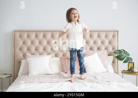 Portrait der glückliche kleine süße Mädchen sprang auf das Bett Spaß Stockfoto