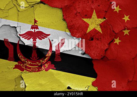 Flaggen von Brunei und China auf gerissene Wand gemalt Stockfoto