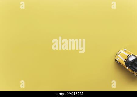 Autovermietung, Reise, Reise oder Wochenend-Aktivität Konzept flach lag mit gelben kleinen Spielzeug Cabriolet Auto auf gelbem Hintergrund Stockfoto