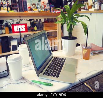 Laptop mit leeren weißen Bildschirm auf Marmor tisch in der modernen Cafe mit Hintergrund Stockfoto