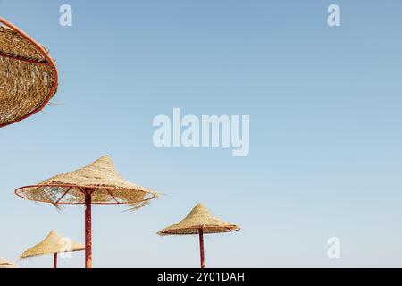 Blick von unten auf einen hölzernen Strohschirm oder eine strohgedeckte Hütte mit wunderschönem Blick auf den blauen Himmel am tropischen Ägyptischen Strand. Sommer- oder Winterurlaub Stockfoto