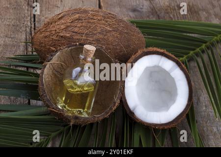 Kokosnuss-Schalen und Öl auf Holz Hintergrund, selektiven Fokus Stockfoto
