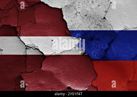 Fahnen von Lettland und Russland auf gerissenen Wänden gemalt Stockfoto