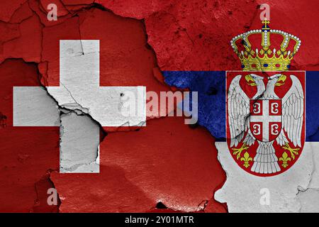 Fahnen der Schweiz und Serbiens auf gerissene Wand gemalt Stockfoto