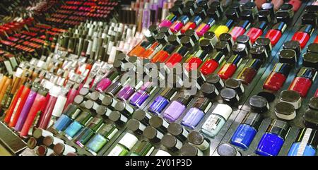 Set mit verschiedenen hellen Nagellacken auf dem Stand in der modernen Kosmetikwerkstatt Stockfoto