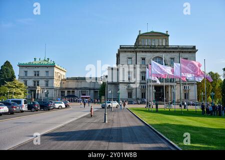 Die Villa Hügel beflagt mit rosa und weißen Flaggen mit dem Krupp Emblem. Es findet eine Veranstaltung statt die gut besucht ist. Die Flaggen wehen im Stockfoto