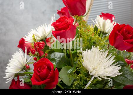 Blick auf einen Blumenstrauß mit roten Rosen und weißen Chrysanthemen. Stockfoto