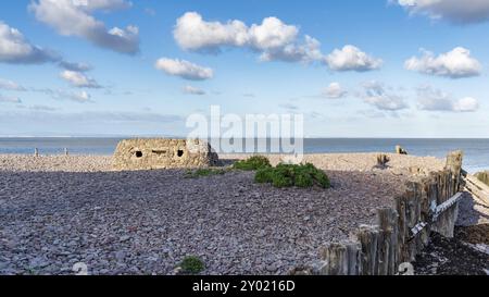 Blick vom Kiesstrand in Porlock Weir, Somerset, England, Großbritannien, mit Blick auf den Bristol Kanal und einen alten Bunker Stockfoto