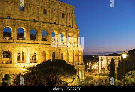 Blick in die Abenddämmerung auf das teilweise römische Kolosseum zusammen mit dem Konstantinsbogen zur blauen Stunde in Rom, Italien, Europa Stockfoto