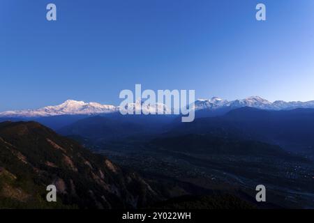 Schneebedeckte Gipfel des Annapurna Himalaya Gebirges beleuchtet durch Sonnenlicht am frühen Morgen, gesehen von Sarangkot, Nepal, Asien Stockfoto