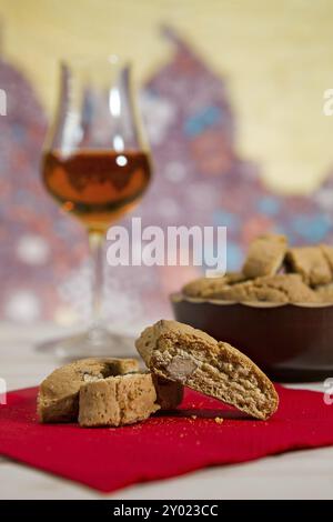 Nahaufnahme des Italienischen cantucci Kekse über einen roten Serviette und ein Glas vin santo Wein auf Hintergrund Stockfoto