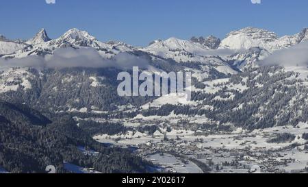 Dorf Saanen und schneebedeckte Berge. Winterszene in den Schweizer Alpen Stockfoto