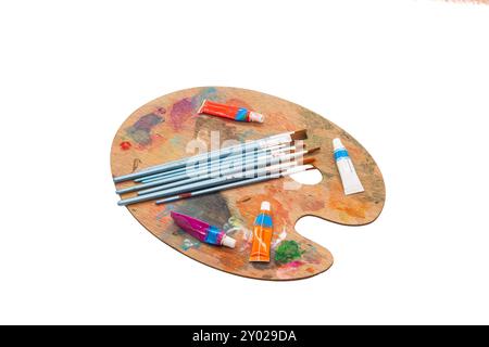 Künstlerische Holzpalette mit bunten Farben und Pinseln für kreative Aktivitäten. Horizontal Stockfoto