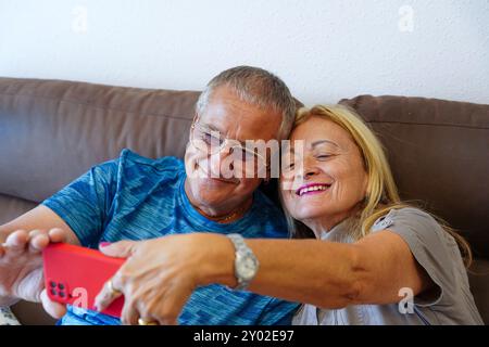 Reife Ehe macht ein Foto mit dem Smartphone auf dem Sofa. Familienzeit Stockfoto