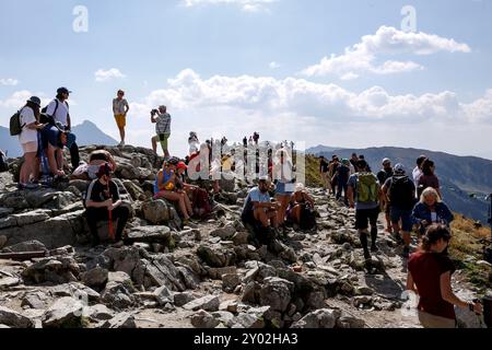 Am letzten Wochenende der Schulferien ruhen sich zahlreiche Touristen auf dem Gipfel des Kasprowy Wierch in der Tatra in Südpolen aus. Die Berge des Tatra-Nationalparks sind sehr überfüllt. Touristen warten manchmal in einer Warteschlange, um einen Gipfel zu erreichen. Stockfoto