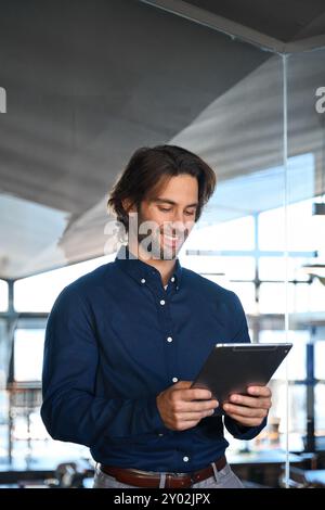 Vertikales Foto eines Geschäftsmannes mit digitaler Tafel im Büro. Stockfoto