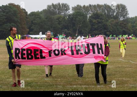 Windsor, Großbritannien. 31. August 2024. Klimaaktivisten der Extinction Rebellion halten einen bannermarsch von ihrem Campingplatz im Home Park ab, um am zweiten von drei Tagen der Aufrüstung Demokratie Briefe an König Karl III. Auf Schloss Windsor zu liefern. Die Kampagne „Upgrade Democracy“ von Extinction Rebellion soll die Art und Weise hervorheben, wie die Gewinne der Öl- und Gasunternehmen im Vereinigten Königreich gesichert werden, und die britische Regierung auffordern, eine Bürgerversammlung für Klima- und ökologische Gerechtigkeit zu gründen und von ihr geleitet zu werden. Quelle: Mark Kerrison/Alamy Live News Stockfoto