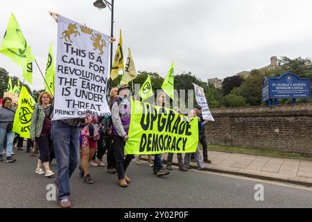 Windsor, Großbritannien. 31. August 2024. Klimaaktivisten, die Banner halten, marschieren nach Windsor Castle, um am zweiten von drei Tagen der Aufrüstung der Demokratie Briefe an König Karl III. Zu liefern. Die Kampagne „Upgrade Democracy“ von Extinction Rebellion soll die Art und Weise hervorheben, wie die Gewinne der Öl- und Gasunternehmen im Vereinigten Königreich gesichert werden, und die britische Regierung auffordern, eine Bürgerversammlung für Klima- und ökologische Gerechtigkeit zu gründen und von ihr geleitet zu werden. Quelle: Mark Kerrison/Alamy Live News Stockfoto