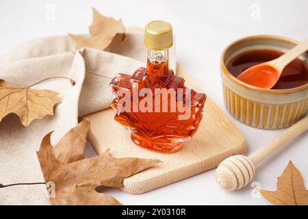 Flasche leckerer Ahornsirup auf grauem Hintergrund Stockfoto