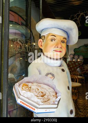 Palma, Spanien - 8. Juli 2024: Statue eines Bäckers mit einem Ensaimada-Gebäck vor Forn de Sant Cristo, einer berühmten Bäckerei in Palma, Mallorca, die für ihre traditionellen mallorquinischen Leckereien bekannt ist Stockfoto