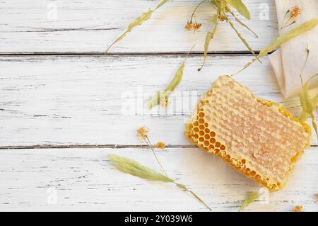 Linden Honigkonzept, Honigwabe mit Lindenblüten auf rustikalem Tisch, gesundes Essen Stockfoto