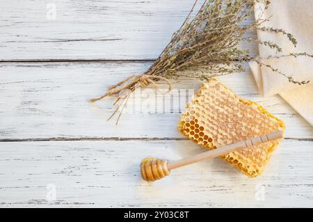 Thymian Honig Konzept, Wabe mit trockenem Thymianbunch auf weißem Holztisch, gesundes Essen Stockfoto