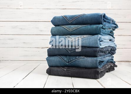 Stack aus verschiedenen Jeans, Hosen auf rustikalem Steinhintergrund, Modedesign Stockfoto