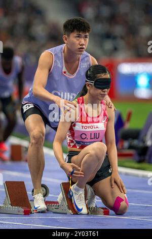 Paris, Frankreich. 30. August 2024. Guide SHENGMING CHEN hilft seinem Läufer CUIQING LIU beim Start des 400-m-T11-Rennens der Frauen bei den Paralympics in Paris 2024 in Position. (Kreditbild: © Mark Edward Harris/ZUMA Press Wire) NUR REDAKTIONELLE VERWENDUNG! Nicht für kommerzielle ZWECKE! Stockfoto