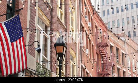 New York City Gebäudearchitektur. Wohnhaus außen. Immobilien, US-Flagge. Typische rote Ziegelfassade. Manhattan Downtown Financial District, Stone Street, FIDI. Fluchtleiter Stockfoto