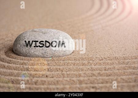 Weisheitstext auf Stein mit Sandstrand-Hintergrund. Beruhigendes Konzept Stockfoto