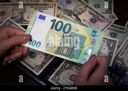 Shanghai, China. 31. August 2024. In dieser Abbildung hält eine Person eine Euro-Barrechnung mit US-Dollar im Hintergrund. (Foto: Sheldon Cooper/SOPA Images/SIPA USA) Credit: SIPA USA/Alamy Live News Stockfoto