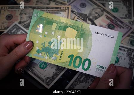 Shanghai, China. 31. August 2024. In dieser Abbildung hält eine Person eine Euro-Barrechnung mit US-Dollar im Hintergrund. (Foto: Sheldon Cooper/SOPA Images/SIPA USA) Credit: SIPA USA/Alamy Live News Stockfoto