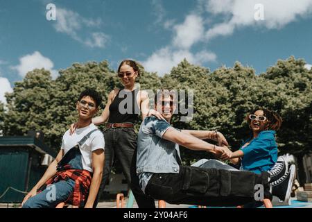 Porträt glücklicher junger männlicher und weiblicher Freunde, die sich auf dem Spielplatz unter bewölktem Himmel Vergnügen Stockfoto
