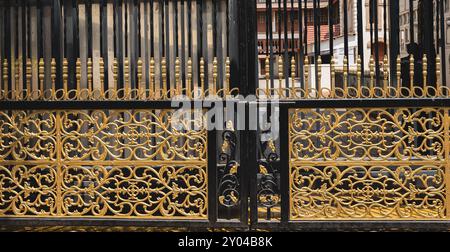 Eiserne Tore mit komplizierten Blumen- und Wirbel-Details. Hausfassade. Schmiedeeiserne Tore im alten Stil. Geschmiedete dekorative Tore. Nahaufnahme des geschmiedeten Orns Stockfoto