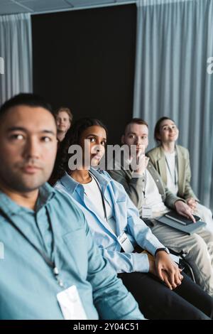 Gruppe männlicher und weiblicher Delegierter, die an einem Seminar im Kongresszentrum teilnehmen Stockfoto