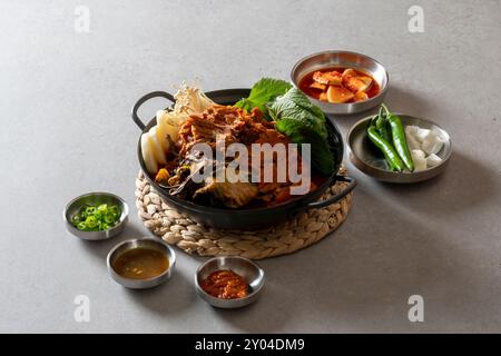 Koreanisches Essen, Gamjatang, Knochenkater-Suppe, Erdtopf, Schweinefleisch-Rückgrat, perilla-Blätter, Beilagen, Stockfoto