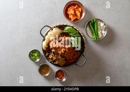 Koreanisches Essen, Gamjatang, Knochenkater-Suppe, Erdtopf, Schweinefleisch-Rückgrat, perilla-Blätter, Beilagen, Stockfoto