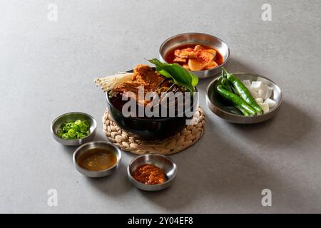 Koreanisches Essen, Gamjatang, Knochenkater-Suppe, Erdtopf, Schweinefleisch-Rückgrat, perilla-Blätter, Beilagen, Stockfoto