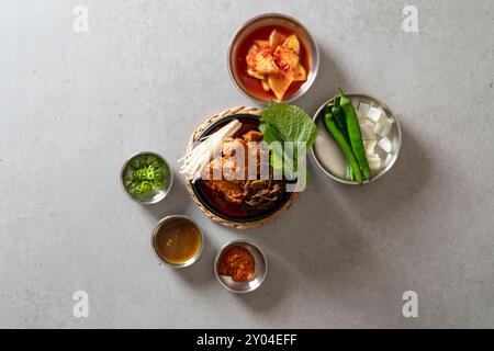 Koreanisches Essen, Gamjatang, Knochenkater-Suppe, Erdtopf, Schweinefleisch-Rückgrat, perilla-Blätter, Beilagen, Stockfoto