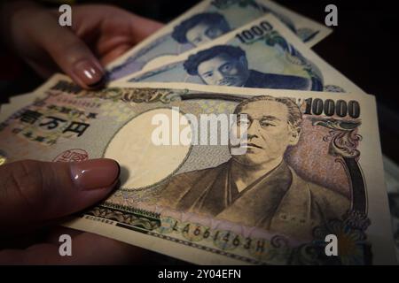 Shanghai, China. 31. August 2024. In dieser Abbildung hält eine Person Barscheine in der japanischen Währung Yen. Quelle: SOPA Images Limited/Alamy Live News Stockfoto